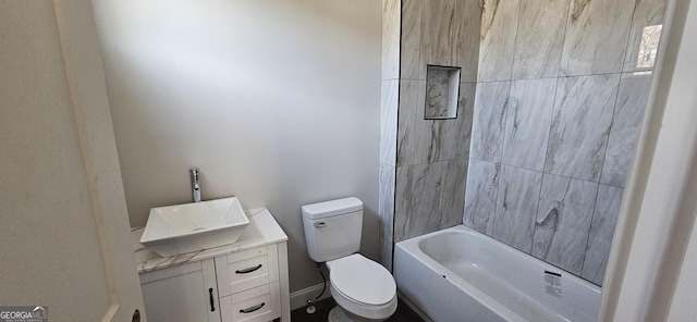 full bathroom with vanity, tiled shower / bath, and toilet