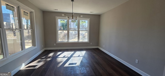 unfurnished dining area featuring dark hardwood / wood-style floors and a chandelier