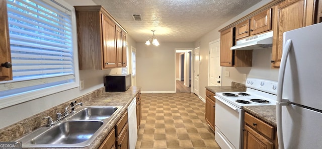 kitchen with pendant lighting, sink, white appliances, an inviting chandelier, and a textured ceiling