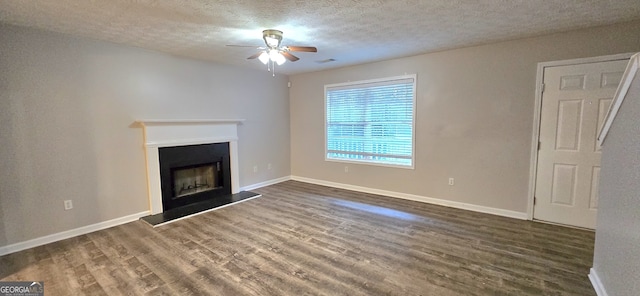 unfurnished living room with ceiling fan, dark hardwood / wood-style floors, and a textured ceiling