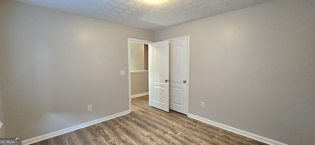 unfurnished bedroom featuring light hardwood / wood-style floors and a textured ceiling