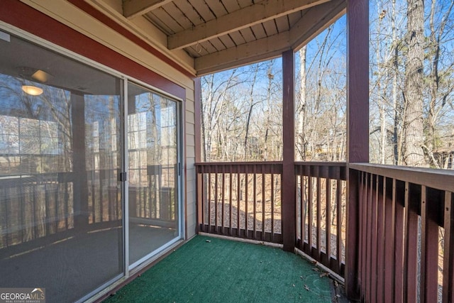 unfurnished sunroom featuring beam ceiling