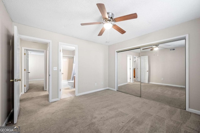 unfurnished bedroom with ceiling fan, light colored carpet, a closet, and a textured ceiling