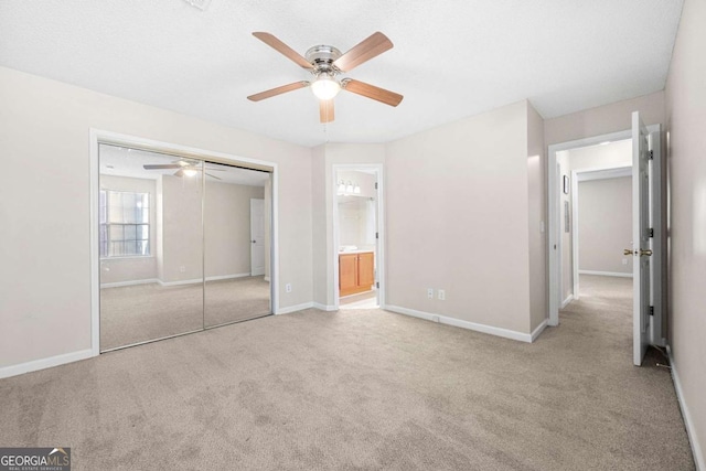 unfurnished bedroom with light carpet, a closet, ceiling fan, and ensuite bathroom