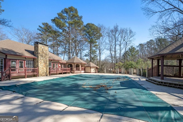 view of pool featuring a wooden deck, a gazebo, and a patio