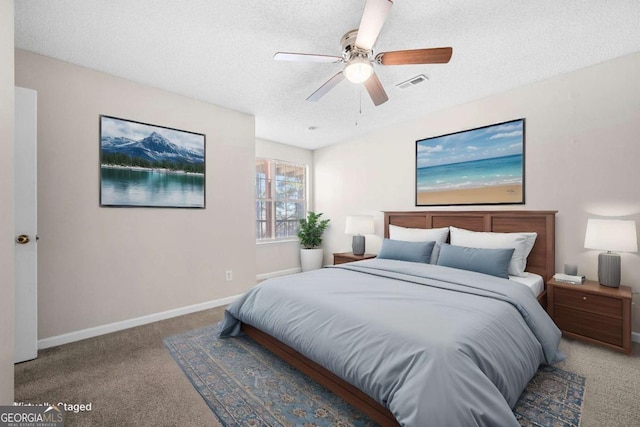 carpeted bedroom with ceiling fan and a textured ceiling