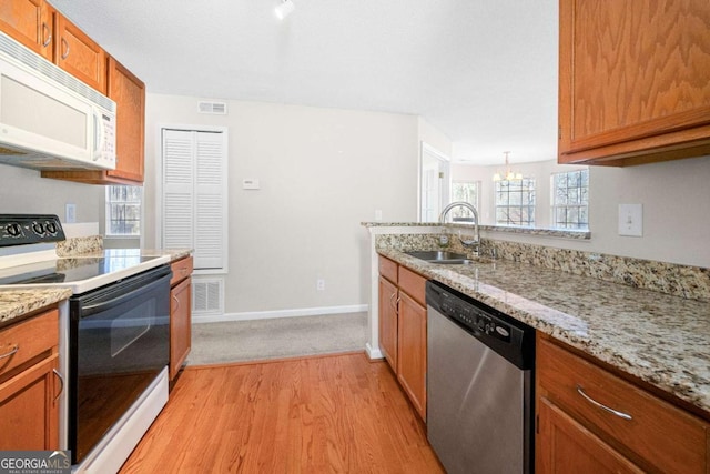 kitchen featuring electric stove, sink, dishwasher, light stone countertops, and light wood-type flooring