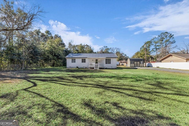 ranch-style home featuring a front yard and a storage unit