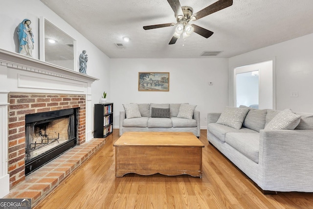 5833 Westerling Pl, Powder Springs, GA 30127 - living area with a fireplace, wood finished floors, a textured ceiling, a ceiling fan, and baseboards