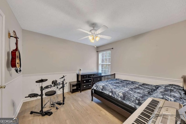 bedroom featuring ceiling fan, a textured ceiling, and light hardwood / wood-style flooring