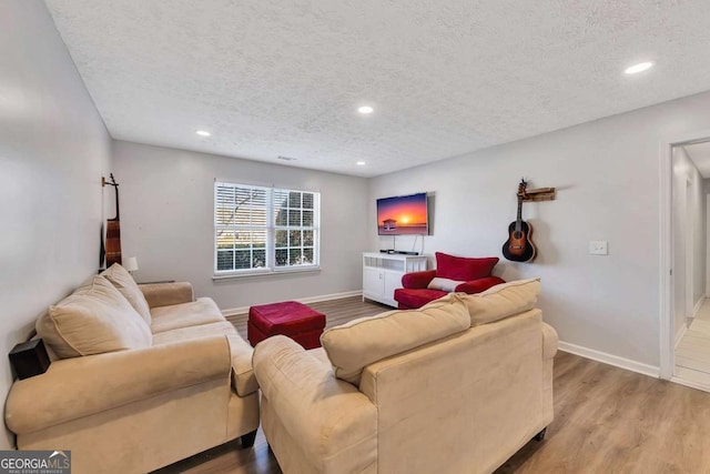 living room featuring light hardwood / wood-style flooring and a textured ceiling