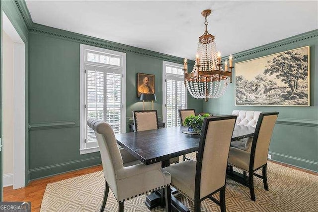 dining room featuring crown molding, a chandelier, and light wood-type flooring