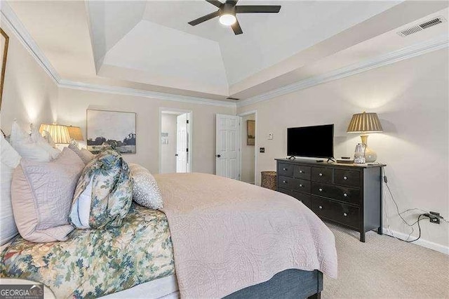 carpeted bedroom featuring a tray ceiling, ornamental molding, and ceiling fan