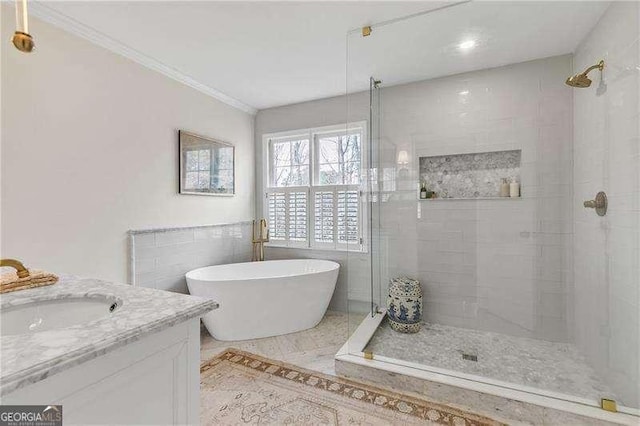 bathroom with crown molding, vanity, shower with separate bathtub, and tile walls