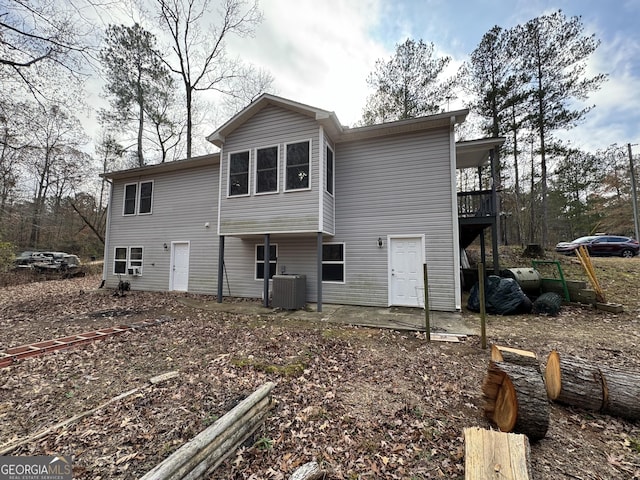 rear view of property with central AC unit and a patio