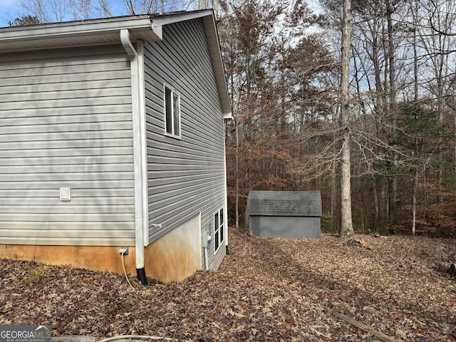 view of side of home featuring a storage shed