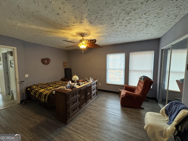 bedroom featuring ceiling fan, dark wood-type flooring, and a textured ceiling