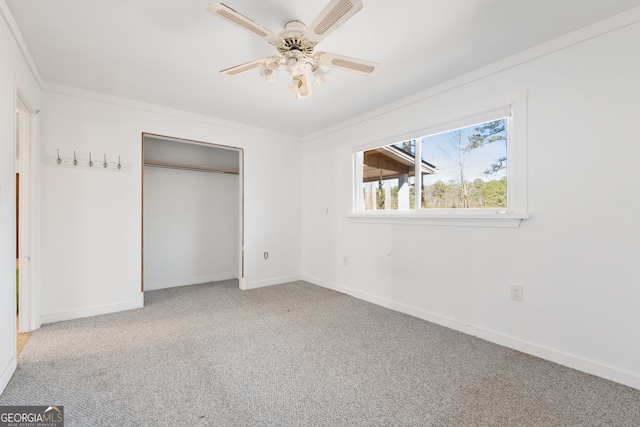 unfurnished bedroom featuring crown molding, a closet, ceiling fan, and light carpet