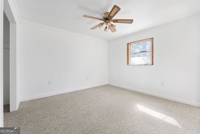 carpeted spare room with crown molding and ceiling fan