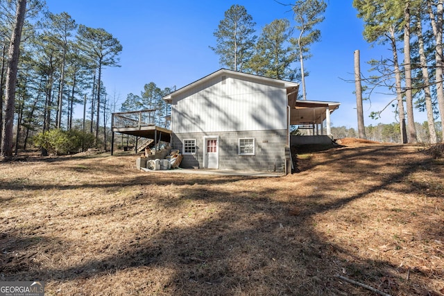 back of house featuring a yard and a deck