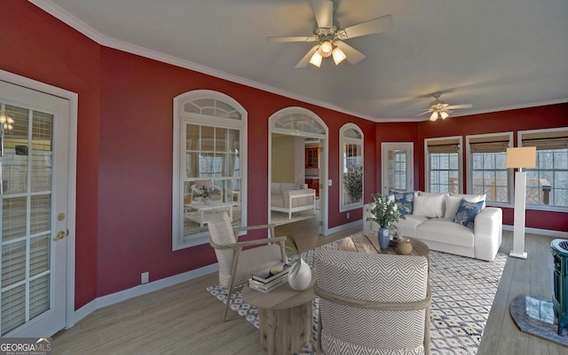 living area featuring light wood-type flooring, baseboards, and ornamental molding