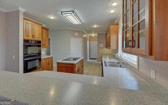 kitchen with crown molding, light countertops, a kitchen island, a sink, and black appliances