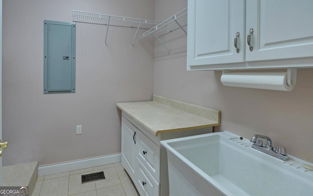 laundry room with light tile patterned floors, a sink, visible vents, baseboards, and electric panel