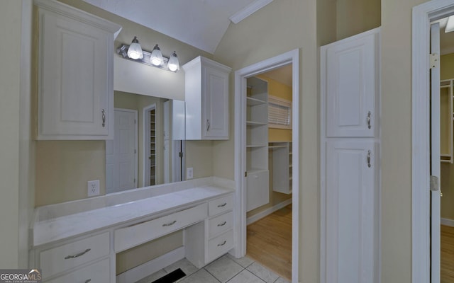 bathroom with lofted ceiling, tile patterned flooring, and vanity