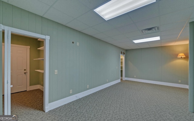 spare room with a paneled ceiling, baseboards, visible vents, and carpet flooring