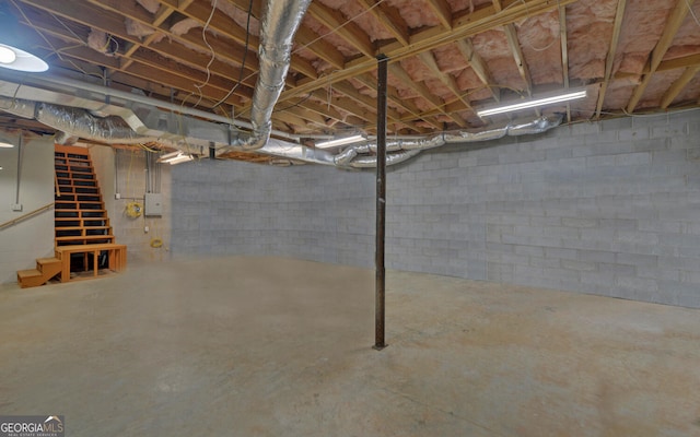 unfinished basement with electric panel and stairs