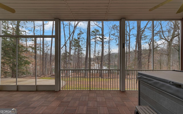 unfurnished sunroom featuring a ceiling fan