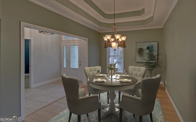 dining room featuring baseboards, a notable chandelier, a raised ceiling, and crown molding