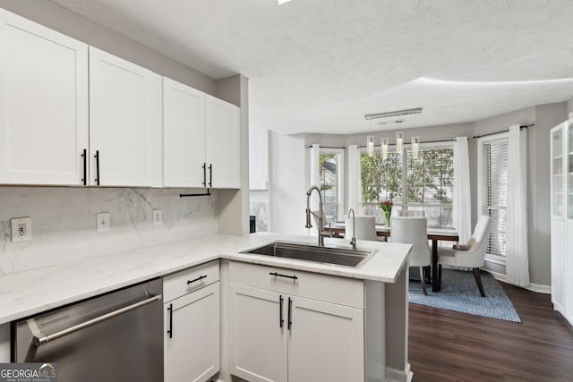 kitchen featuring white cabinetry, stainless steel dishwasher, kitchen peninsula, and sink