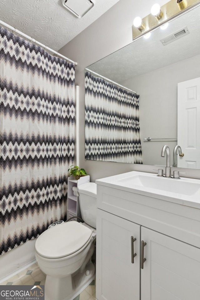 bathroom with vanity, a textured ceiling, and toilet