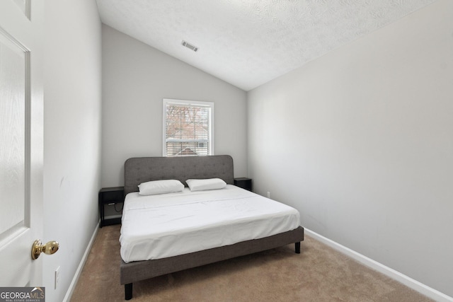 carpeted bedroom featuring lofted ceiling and a textured ceiling