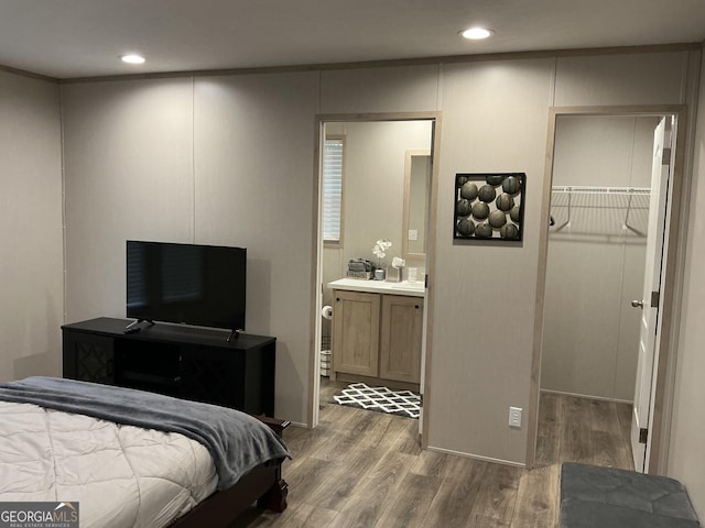 bedroom featuring dark wood-type flooring, ensuite bath, a spacious closet, and a closet