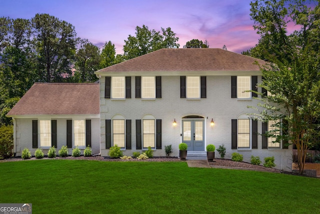 colonial home with a lawn and french doors