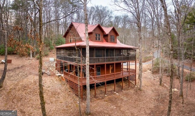 rear view of property with a wooden deck and a sunroom