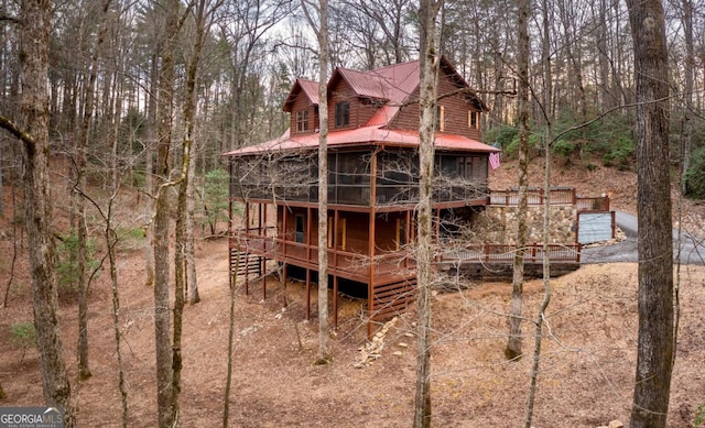 back of house with a wooden deck and a sunroom