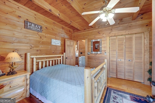 bedroom featuring beamed ceiling, wood-type flooring, wooden walls, and wooden ceiling