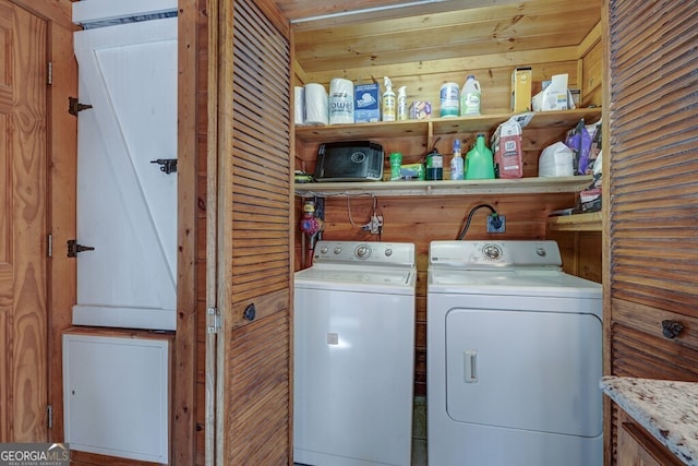 washroom featuring independent washer and dryer and wooden walls