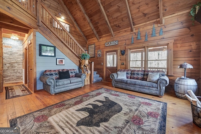 living room with beam ceiling, wooden ceiling, and wood walls