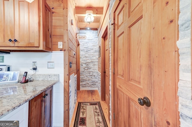 kitchen with light wood-type flooring and light stone counters