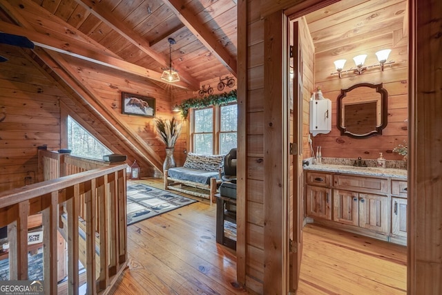 hallway featuring wood ceiling, wooden walls, and light wood-type flooring