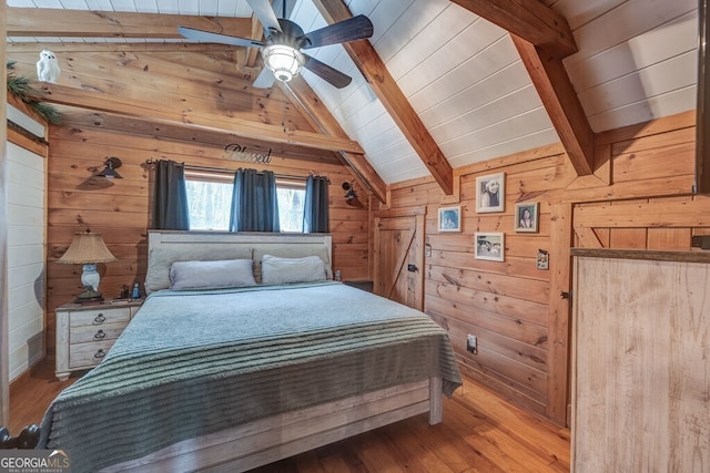 bedroom featuring wooden walls, lofted ceiling with beams, and light hardwood / wood-style flooring