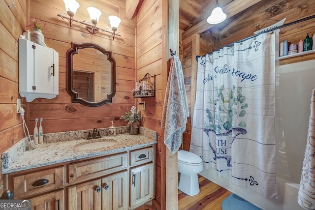 full bathroom with shower / bath combo, wooden walls, vanity, wood-type flooring, and toilet