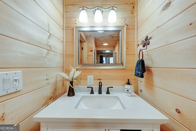 bathroom featuring vanity and wooden walls