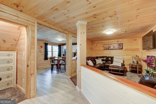 living room featuring wooden ceiling, wooden walls, and light hardwood / wood-style flooring