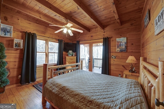 bedroom with wood ceiling, hardwood / wood-style flooring, access to exterior, beam ceiling, and wood walls