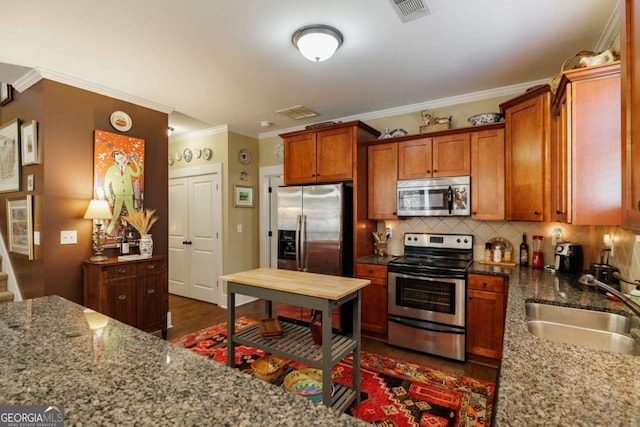 kitchen featuring stone countertops, tasteful backsplash, sink, stainless steel appliances, and crown molding